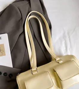 Detail view of smooth dual shoulder straps on a creamy beige minimalist tote bag