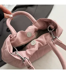 Close-up of the magnetic buckle design and inner lining on a pink pleated cloud bag
