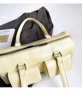 Detail of smooth silver zipper and front buckled pockets on vintage cream Boston bag