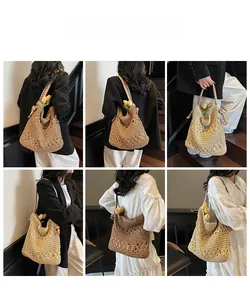 Dettaglio della borsa tote in paglia intrecciata con tracolla etnica su borsa a spalla