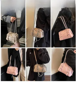 Detail view of stylish Boston handbags in beige and pink with metal chain handles