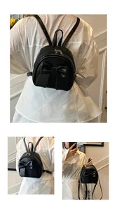 Detail shots of small black backpack featuring a large bow and adjustable straps