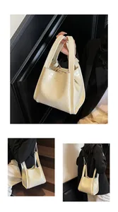 Détails du sac seau crème à motif crocodile avec double poignée et texture précise
