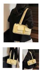 Detail of a bright yellow retro handbag with functional double pockets and smooth leather finish
