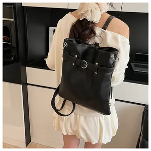 Detail view of black matte leather backpack with silver metal rings and buckle details