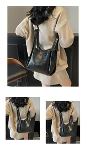 Détails de la texture crocodile noire sur sac seau avec clous de protection dorés