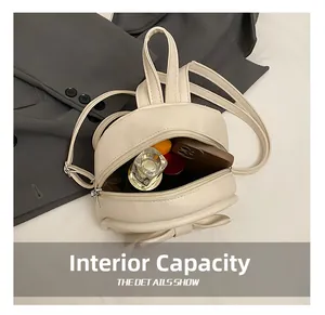 Detail view of mini backpack interior showing capacity for phone and cosmetics
