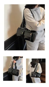 Close-up of black glossy underarm bag with double flap pockets and silver metal buckles