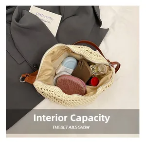 Detail view of the beige woven beach bag's interior storage and brown leather strap