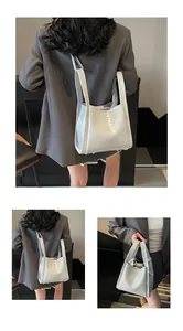 Détail de la texture cuir croco blanc et des doubles poignées sur ce sac seau élégant