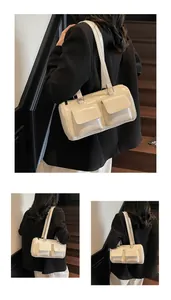 Detailed view of cream white patent leather shoulder bag with dual front flap pockets