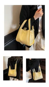 Détail du sac seau jaune pâle avec texture gaufrée crocodile et bandoulière amovible
