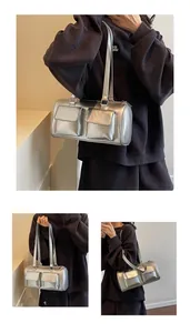 Detail view of silver metallic shoulder bag featuring dual front flap pockets and straps