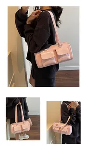 Detail of pink patent leather shoulder bag with glossy finish and two front flap pockets