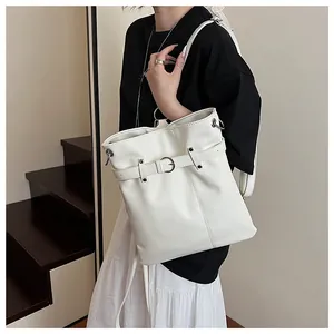 Detail of ivory PU leather bucket bag with silver metal buckle and adjustable strap