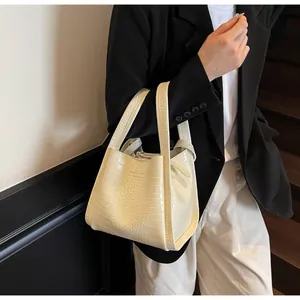 Crocodile pattern leather bucket bag in cream white shown as a stylish shoulder bag