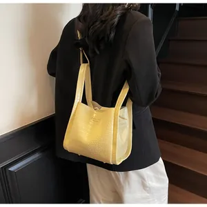 Detail of cream crocodile embossed bucket bag featuring classic style fashion text