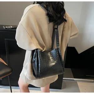 Détail de la texture crocodile noire d'un sac seau avec des boucles métalliques de qualité