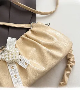 Détail du sac à bandoulière en similicuir crème avec dentelle cœur et perles douces