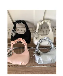 Detail of four cloud-pleated handbags with metallic heart charms in multiple colors