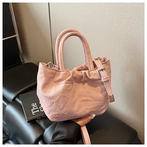 Detail view of pink gathered bucket bag with round handles and adjustable strap