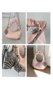 Detail of soft leather dumpling bag with ruched handle and silver heart charm accessory
