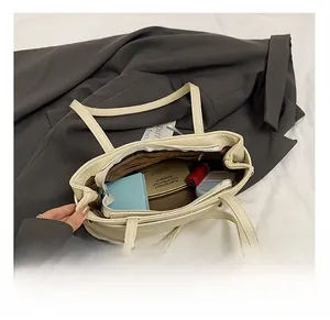 Internal view of cream shoulder bag showing spacious interior with zipper pocket