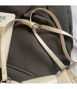 Détail de la bandoulière réglable blanc crème avec texture croco et boucle argentée