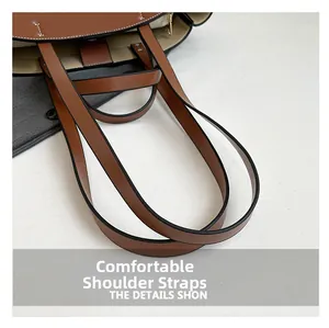 Detail view of brown leather tote bag showing smooth dual straps and fine stitching
