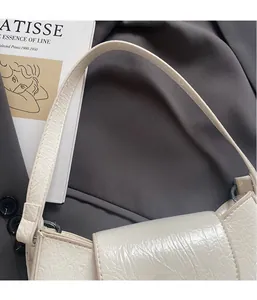 Détail d'un sac en cuir blanc embossé crocodile avec une finition brillante élégante