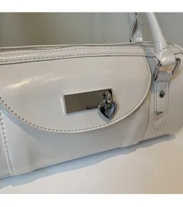 Close-up of white glossy bowling bag showing silver metal zippers and heart charm details