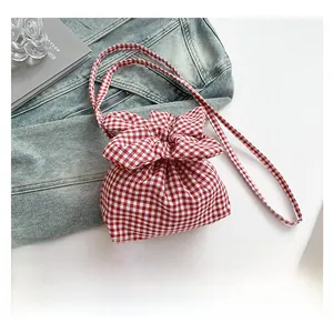 Détail du sac bandoulière vichy rouge et blanc avec grand nœud et fermeture à cordon