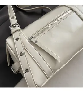 Detail of cream pillow bag showing silver eyelets and high-quality synthetic leather texture