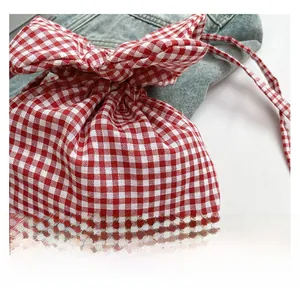 Détail du sac à cordon en coton à carreaux rouge et blanc sur denim bleu