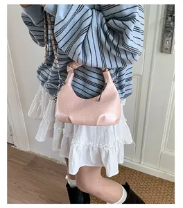 Detail of pink faux leather cloud bag with ruched handle and silver chain strap