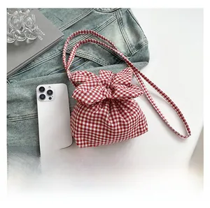 Vue détaillée du sac à fleurs vichy rouge avec cordon de serrage et accessoires de mode