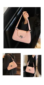 Détail d'un sac à bandoulière rose en similicuir plissé avec fermoir métallique argenté