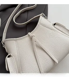 Detail der cremeweißen Schultertasche aus weichem Leder mit feiner Lychee-Maserung