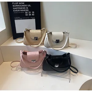 Détail de sacs sous le bras plissés en beige, blanc, rose et noir avec boucle en métal chic