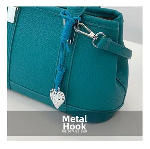 Detail of lychee pattern leather handbag with silver hardware and heart charm