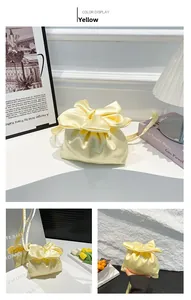 Détail du sac à cordon en satin jaune avec un grand nœud décoratif et des anses en soie