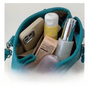 Interior view of leather handbag showing large capacity for phone and cosmetics