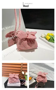 Détail du sac à bandoulière vichy rouge avec grand nœud et texture en coton