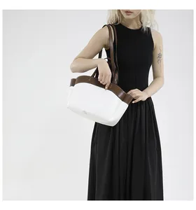 Detail of a large minimalist tote bag in white and brown leather on model