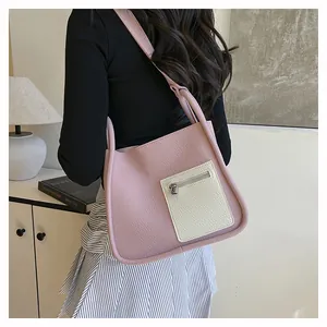 Detail showing the lychee texture of the pink and white faux leather shoulder bag