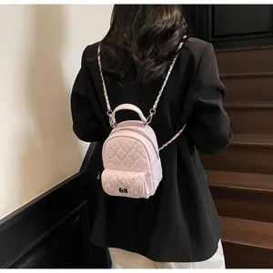 Rear view of pink quilted mini backpack with rhinestones and chain straps on a model