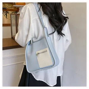 Close-up of contrast color shoulder bag in blue and white with litchi grain texture
