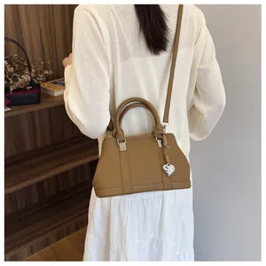 Brown lychee pattern handbag with silver heart charm and slender crossbody strap