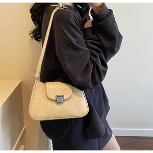 Vue détaillée du sac sous le bras beige avec un fermoir à bouton-pression en argent