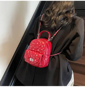 Rear view of a red quilted mini backpack with pearls and diamonds on a model's back